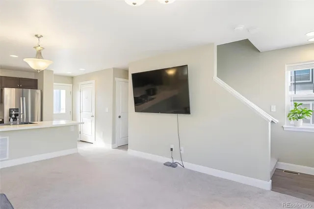 a living room with a flat screen tv and white walls