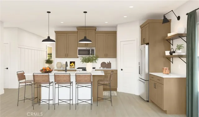 a kitchen with stainless steel appliances kitchen island granite countertop a table chairs and a refrigerator