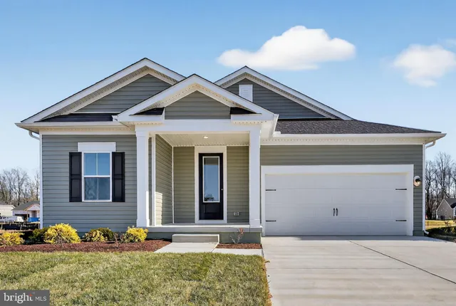 a front view of a house with an yard and seating space