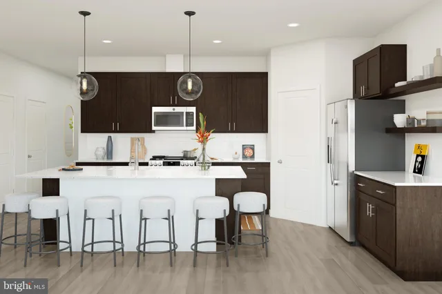 a kitchen with stainless steel appliances granite countertop a stove top oven a sink a refrigerator and chairs