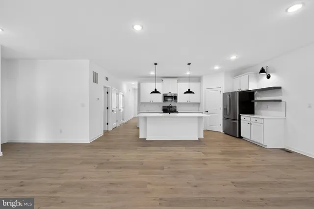a kitchen with white cabinets and refrigerator