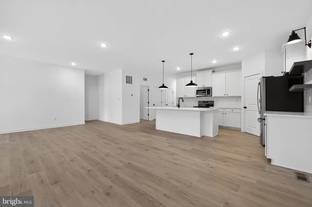 a view of kitchen with refrigerator and wooden floor