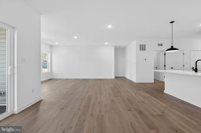 a view of empty room with wooden floor and window