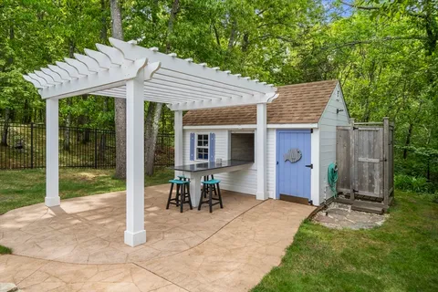 a backyard of a house with yard barbeque oven and outdoor seating