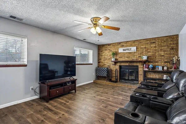 a living room with furniture a flat screen tv and a fireplace