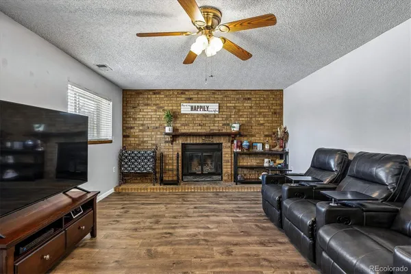 a living room with furniture a flat screen tv and a fireplace