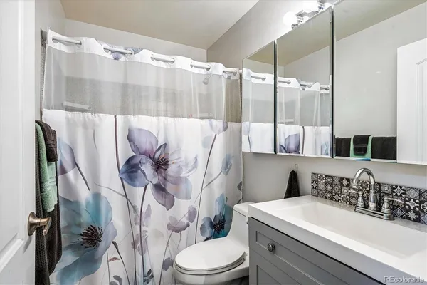 a bathroom with a sink a toilet and a mirror