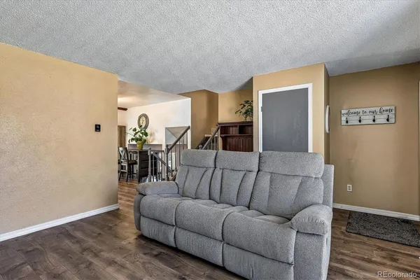 a living room with furniture and wooden floor