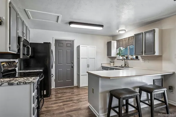 a kitchen with kitchen island a sink stove and refrigerator