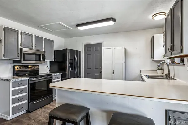 a kitchen with stainless steel appliances a refrigerator stove microwave and sink