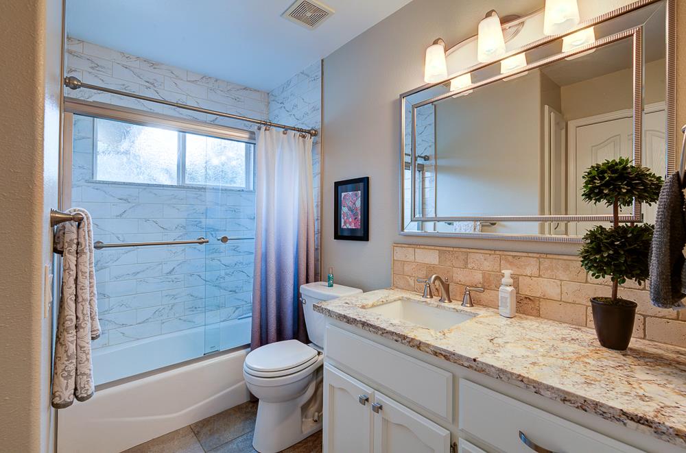 17465 Monreal Road Madera, CA 93636 - Photo 42 of 59 a bathroom with a granite countertop sink toilet and shower
