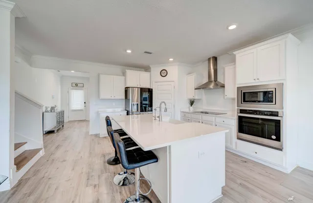 a large white kitchen with stainless steel appliances