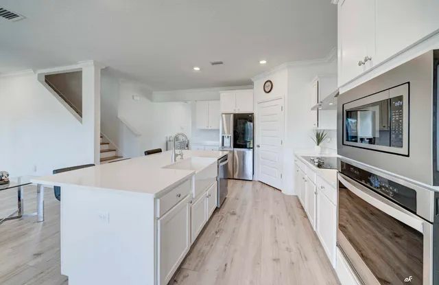 a kitchen with a refrigerator a stove top oven and a sink