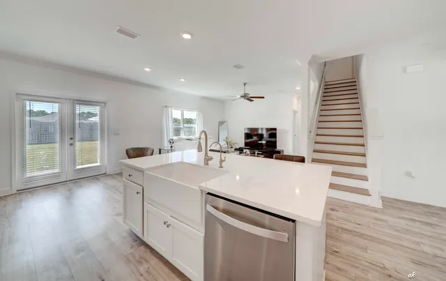 a kitchen with a sink and wooden floor