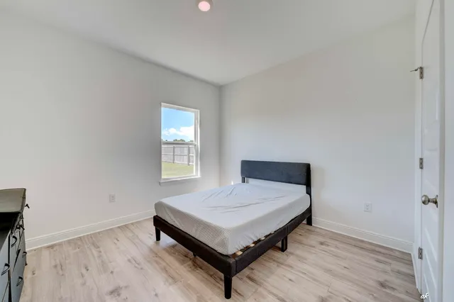 a bedroom with a bed table and window