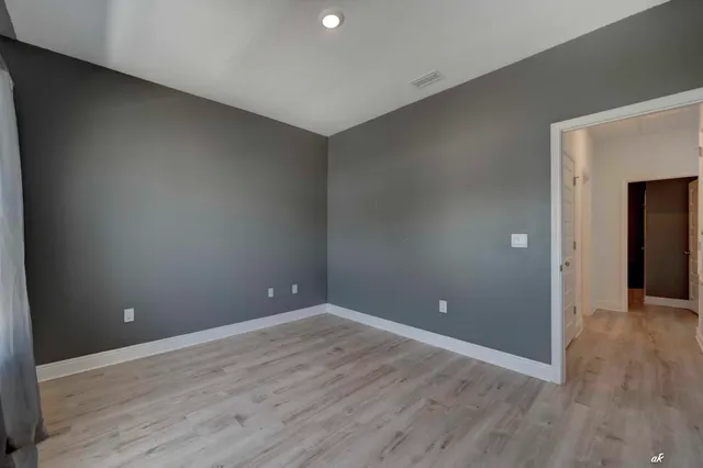 a view of an empty room with wooden floor