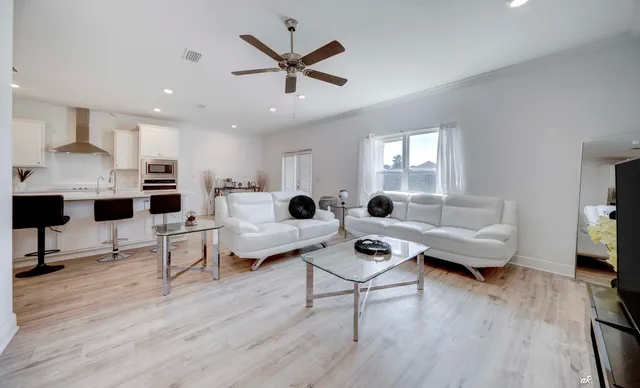 a living room with furniture and a wooden floor