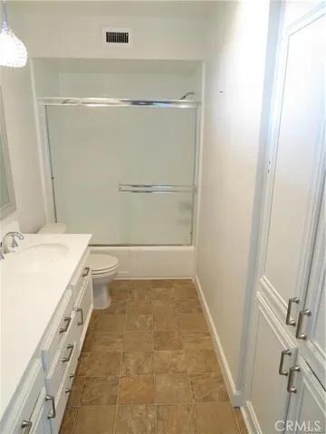 a bathroom with a granite countertop sink a toilet and a mirror
