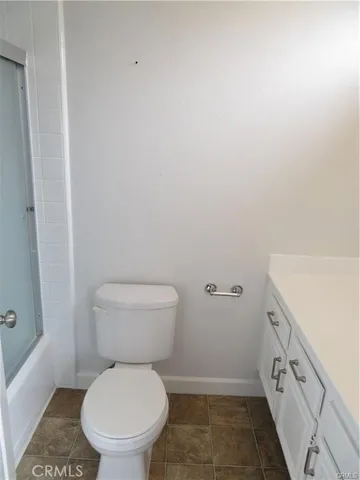 a white toilet sitting next to a white sink and vanity