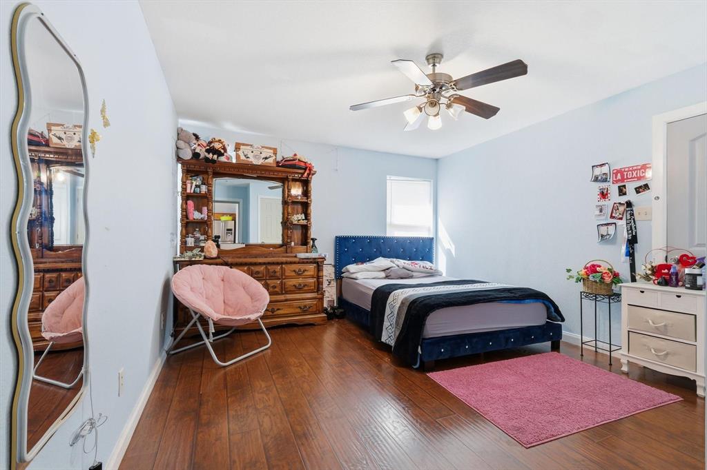 114 Drake Lane Garland, TX 75043 - Photo 14 of 27 a bedroom with a bed and a chandelier