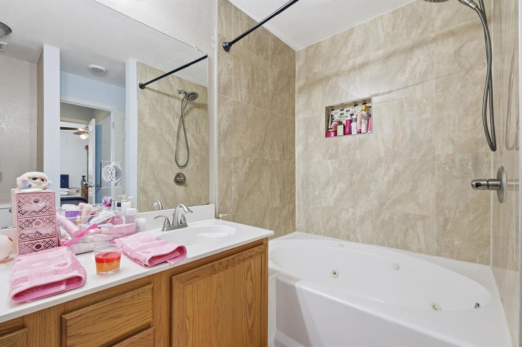 114 Drake Lane Garland, TX 75043 - Photo 17 of 27 a bathroom with a sink vanity mirror and a bathtub
