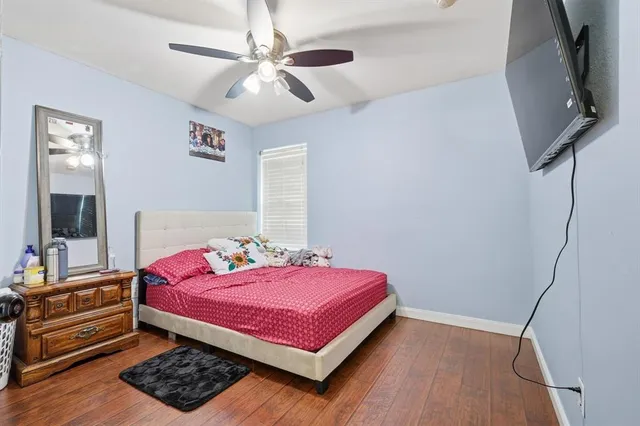 a bedroom with a bed and a mirror on the dresser