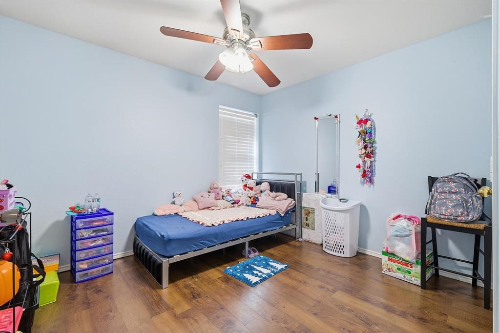 114 Drake Lane Garland, TX 75043 - Photo 21 of 27 a bedroom with furniture and a wooden floor