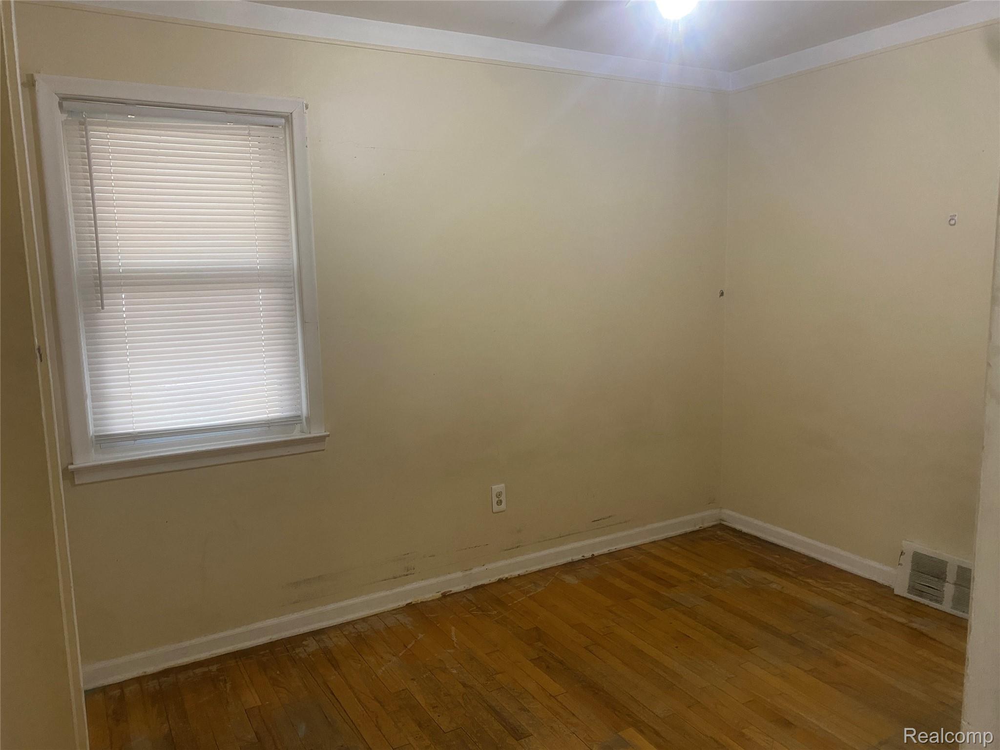 180 West Rutgers Avenue Pontiac, MI 48340 - Photo 17 of 33 Unfurnished room featuring hardwood / wood-style flooring and ornamental molding