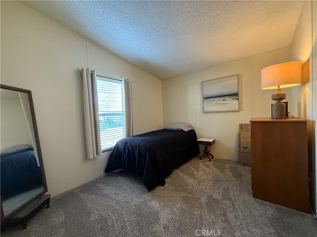 a bedroom with a bed and a potted plant