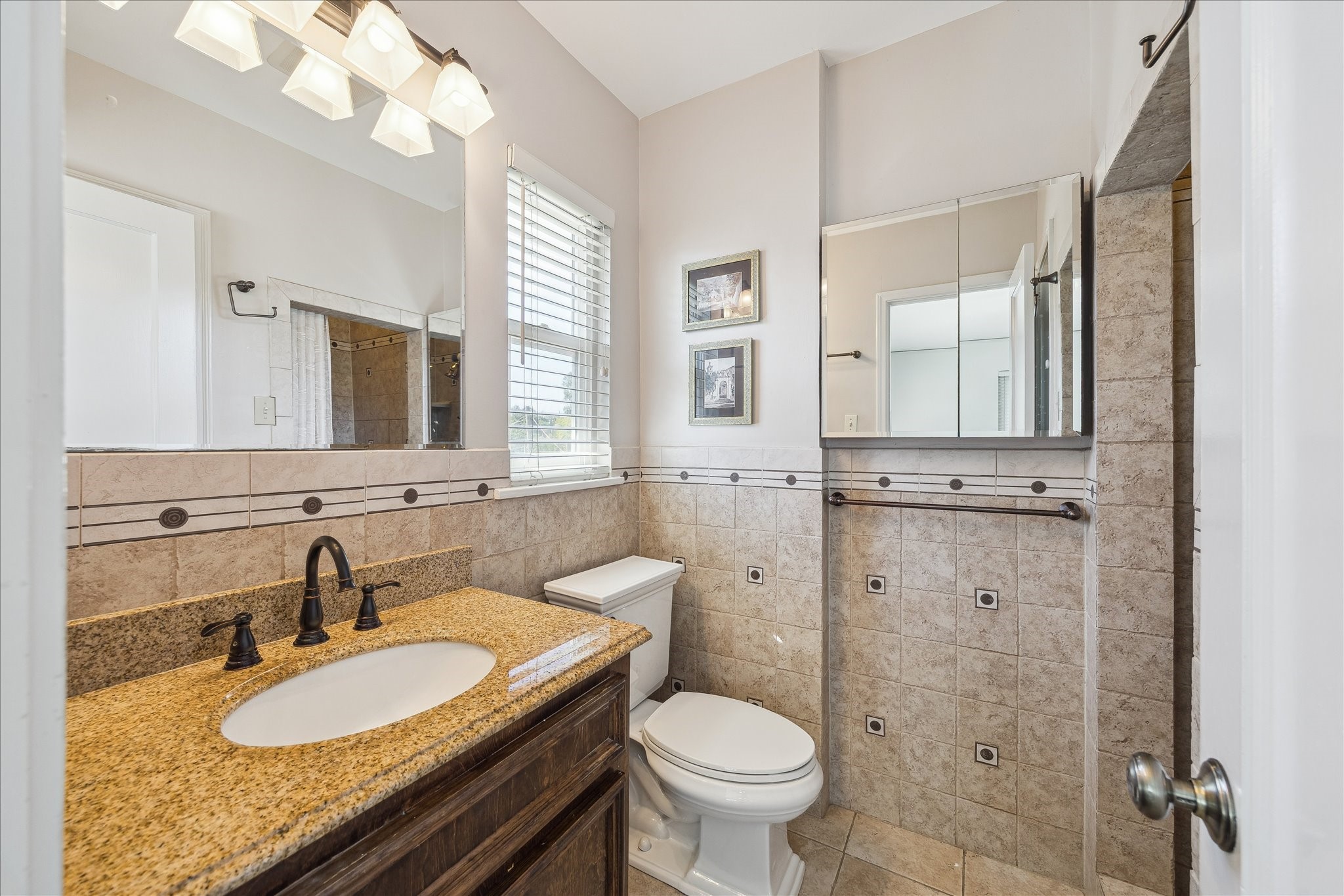 4388 Fiesta Lane Houston, TX 77004 - Photo 17 of 24 a bathroom with a granite countertop double vanity sink a mirror and a toilet