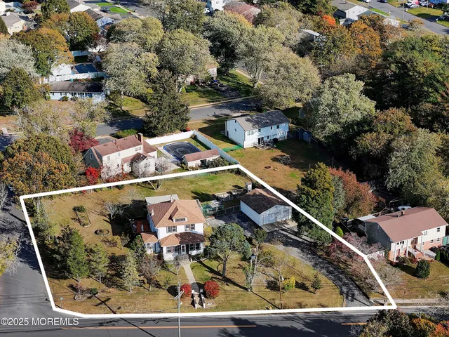an aerial view of a house with a yard and large trees