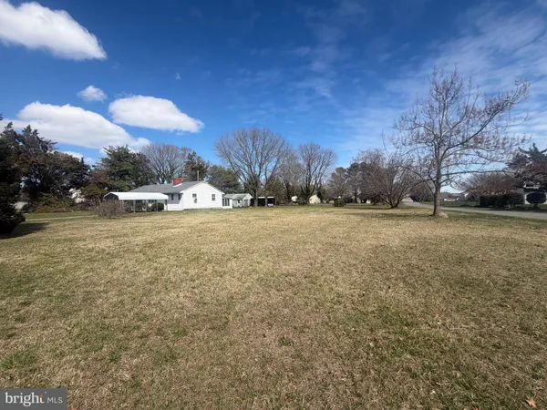 a view of a field with a building in the background