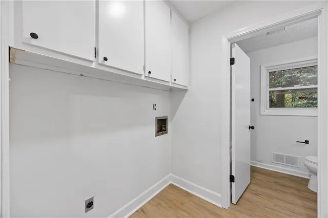 a view of storage and utility room with wooden floor