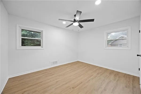 a view of empty room with wooden floor