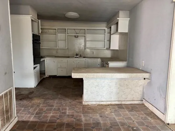 a view of kitchen with cabinets and window