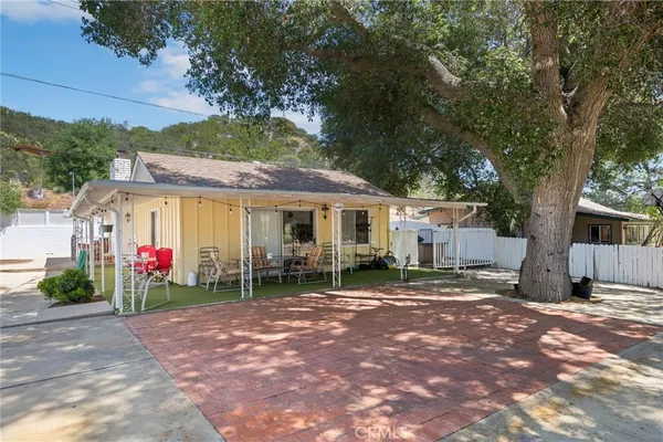 a view of a house with backyard and a tree