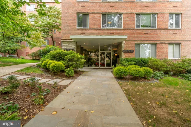 front view of a brick house with a yard