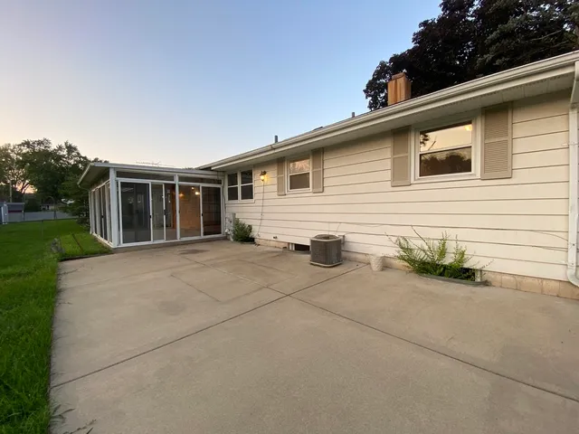 a view of house that has a car park side of road
