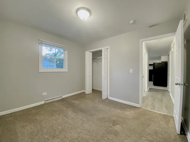 an empty room with windows and closet