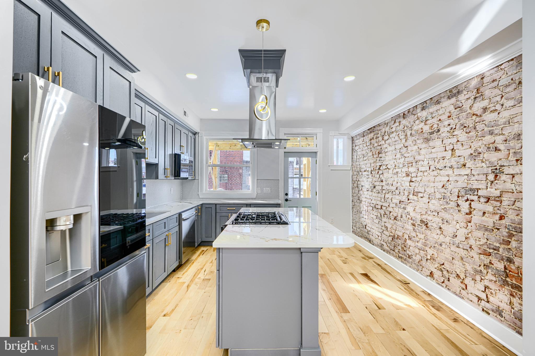 3825 Foster Avenue Baltimore, MD 21224 - Photo 11 of 54 a kitchen with stainless steel appliances granite countertop a refrigerator a stove and a sink with wooden floor