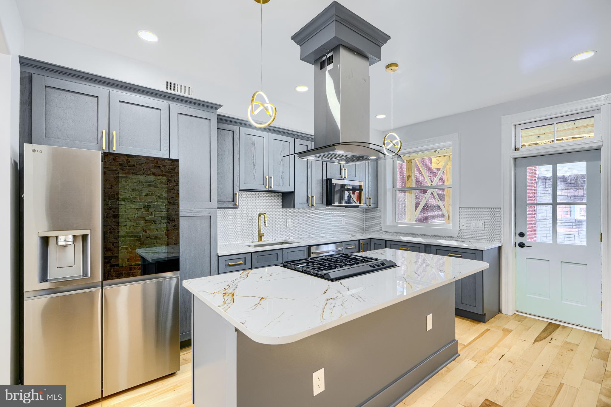 3825 Foster Avenue Baltimore, MD 21224 - Photo 13 of 54 a kitchen that has a lot of cabinets in it and wooden floors