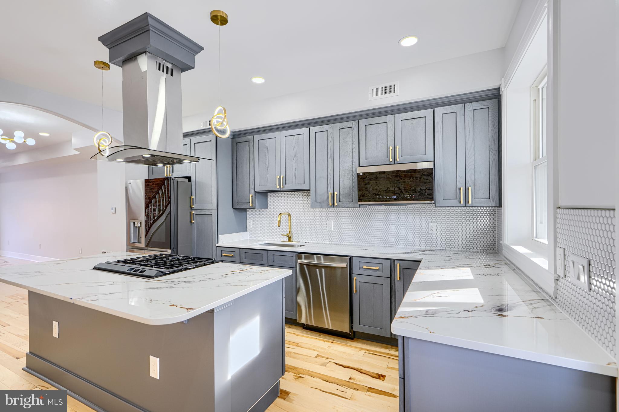 3825 Foster Avenue Baltimore, MD 21224 - Photo 14 of 54 a kitchen with kitchen island a sink stainless steel appliances and cabinets