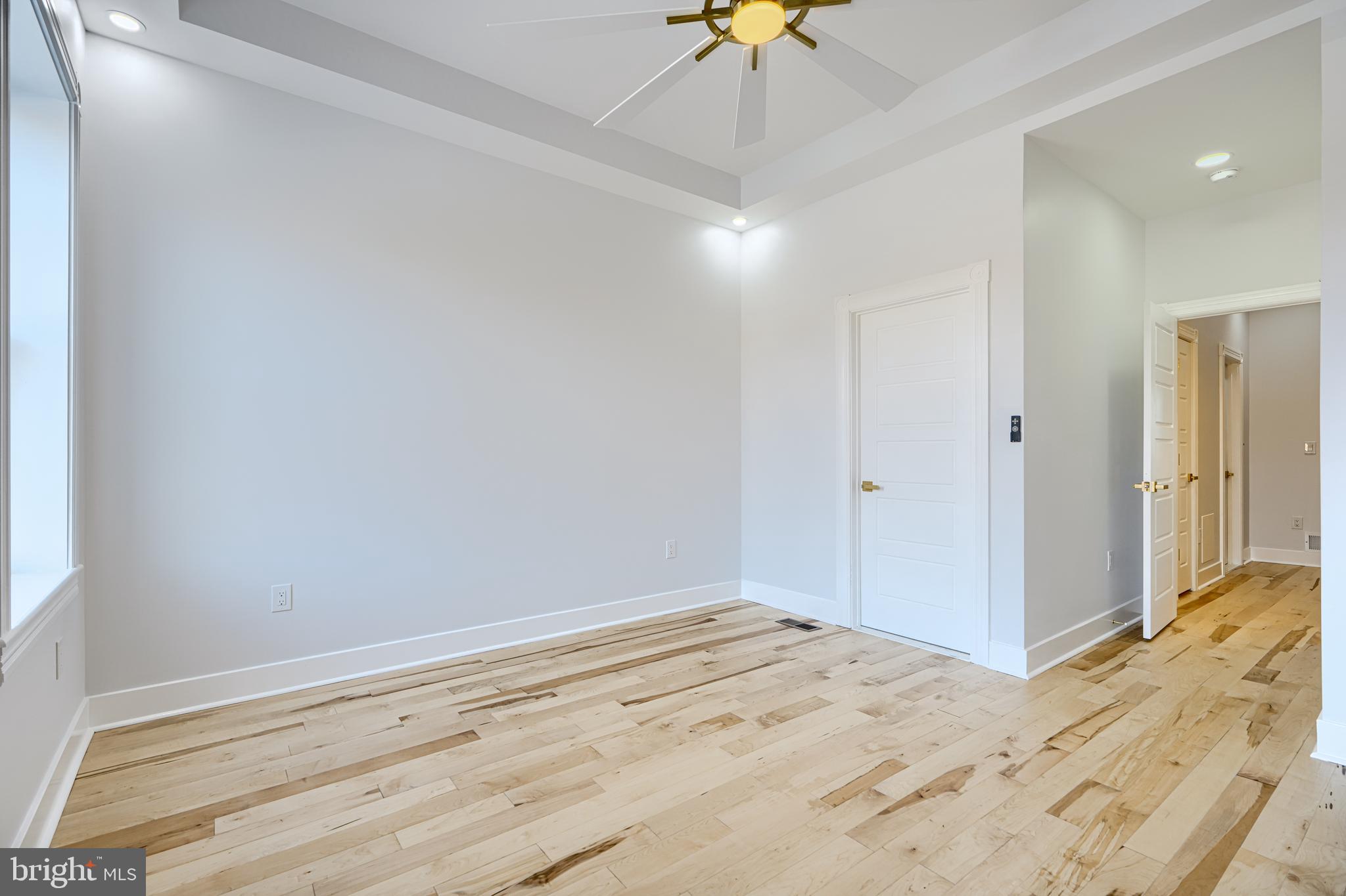 3825 Foster Avenue Baltimore, MD 21224 - Photo 18 of 54 an empty room with a chandelier fan and wooden floor