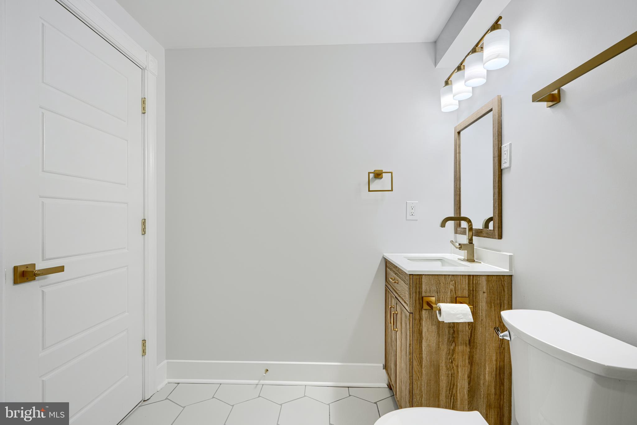 3825 Foster Avenue Baltimore, MD 21224 - Photo 47 of 54 a bathroom with a toilet a sink and mirror