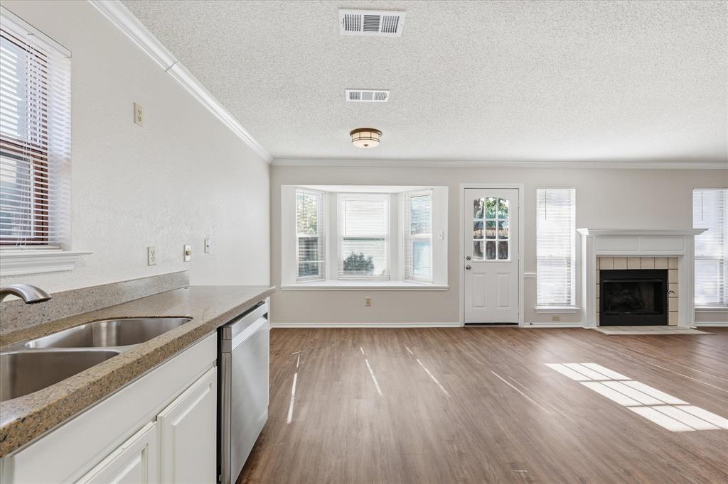 318 Lodge Road Coppell, TX 75019 - Photo 18 of 35 Bright and open, the kitchen and breakfast area feature stainless appliances, ample natural light and a welcoming fireplace view