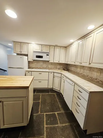 a kitchen with a cabinets and white appliances