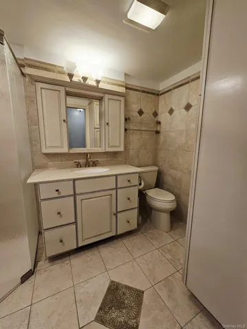 a spacious bathroom with a granite countertop sink toilet and mirror