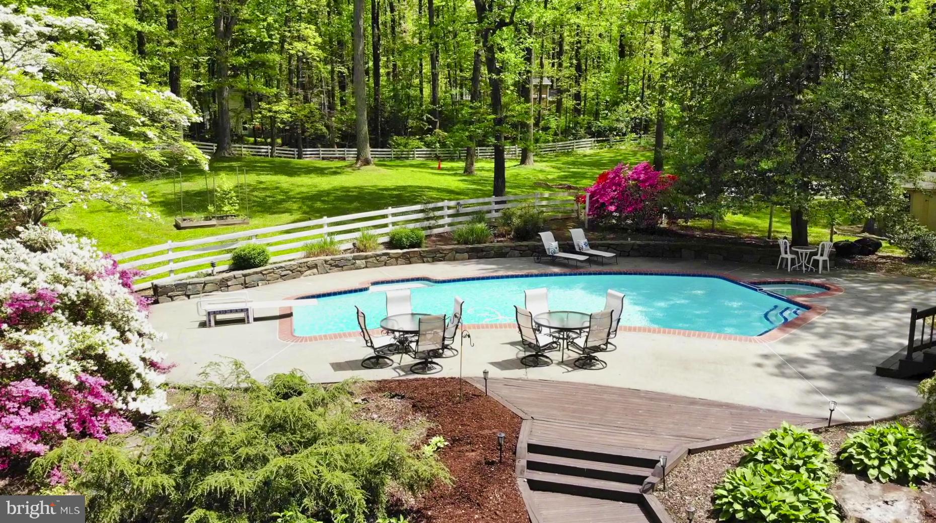 a view of a swimming pool with a patio and garden