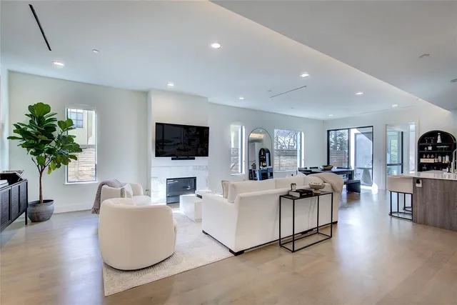 a living room with furniture a flat screen tv and a potted plant