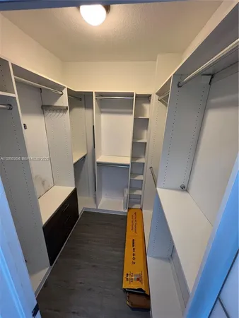 a view of walk in closet with empty racks